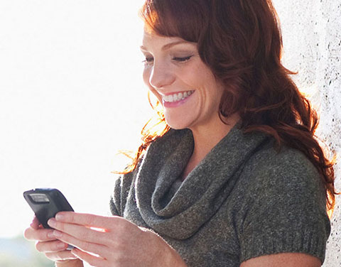 Mujer riendo con un teléfono móvil